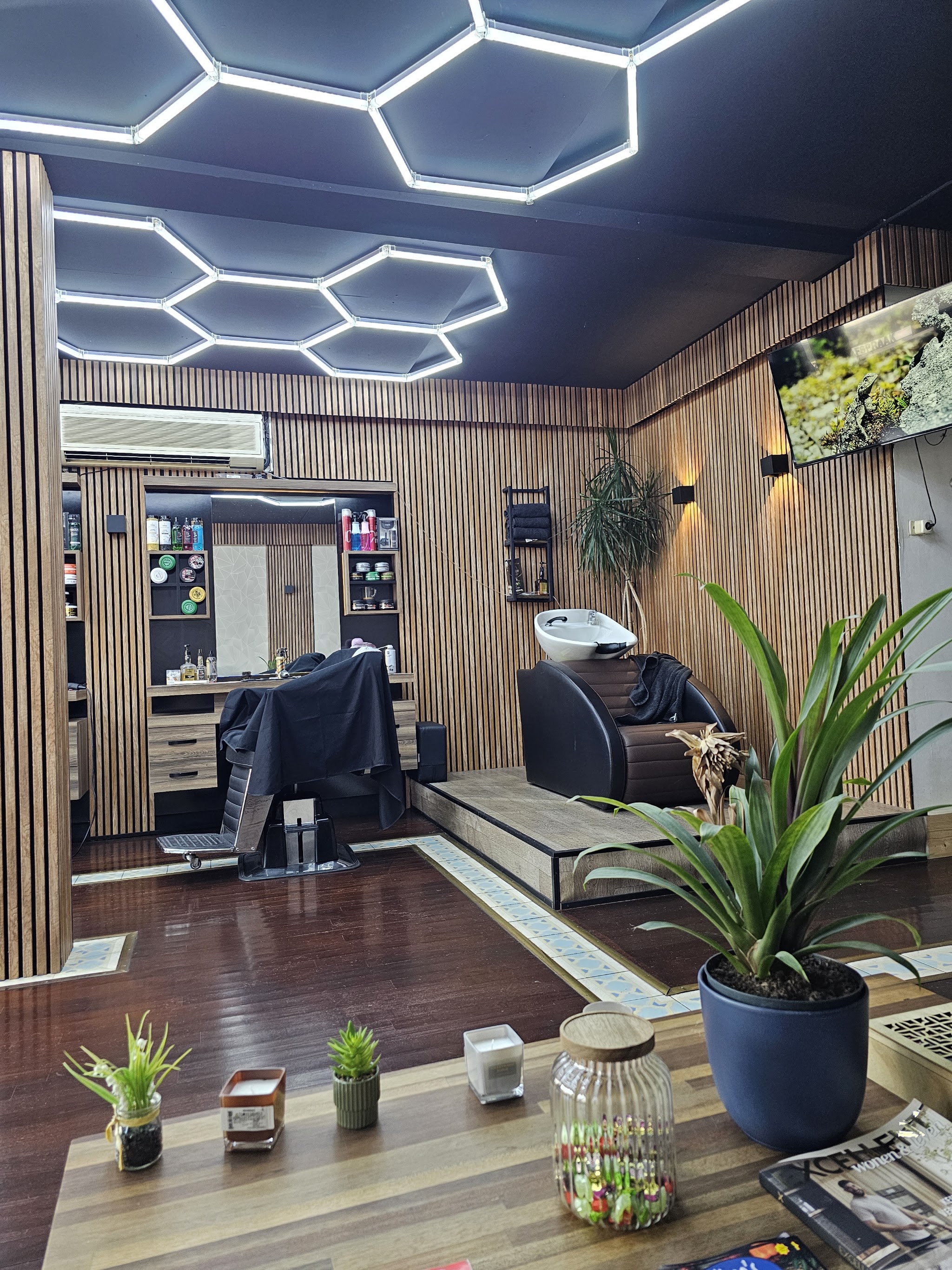 Het interieur van Barber A-Z, met de wasunit op een verhoging en eiken lattenwanden