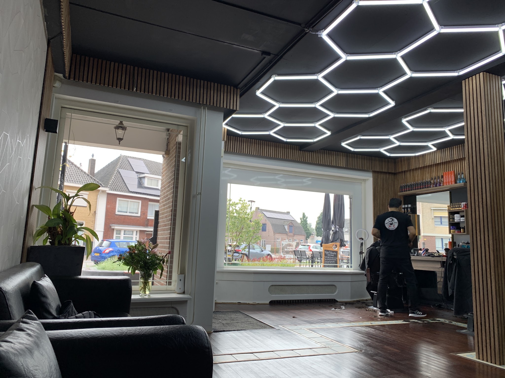 De zaak van Barber A-Z in Waalre overdag, met zeshoekige ledverlichting en grote ramen op de straat
